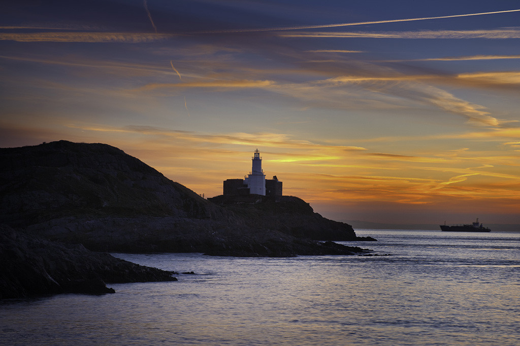 Mumbles Head lighthouse at sunrise from Bracelet Bay, Gower Peninsula